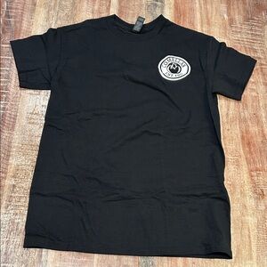 Gildan Black Short Sleeve Crewneck Tee with White Comella’s Logo.